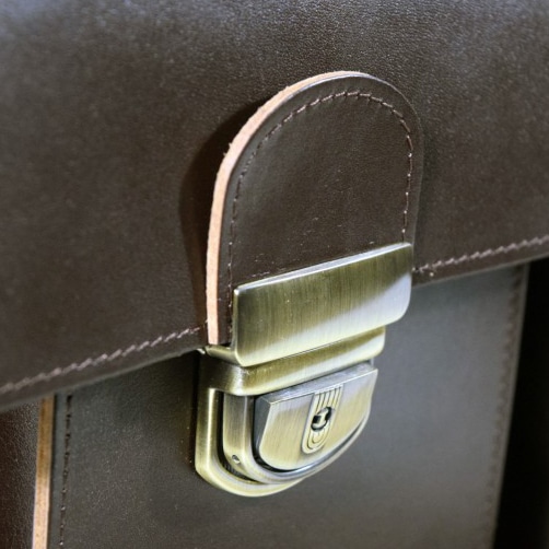 a close up of a brown briefcase with a metal handle.