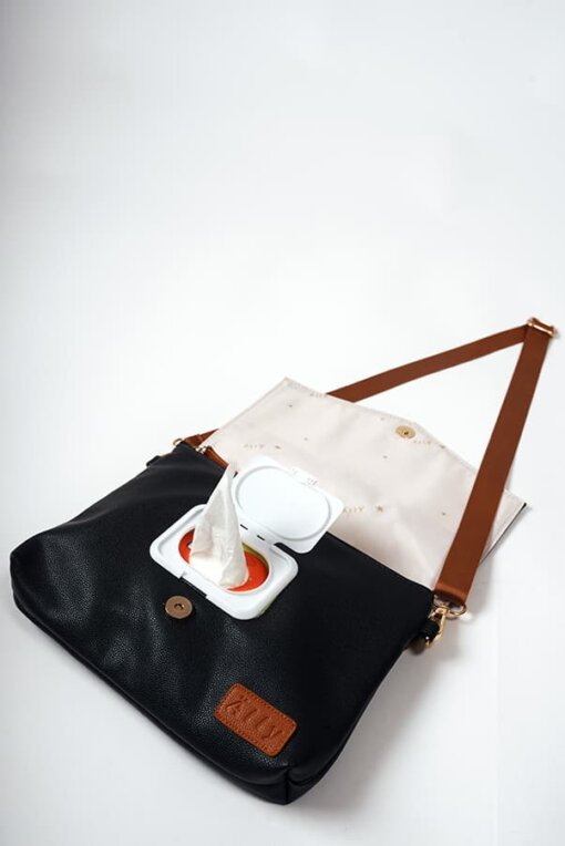 a black and white bag with a brown strap.