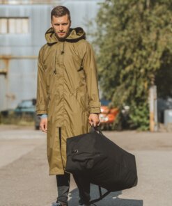 a man in a raincoat carrying a large bag.