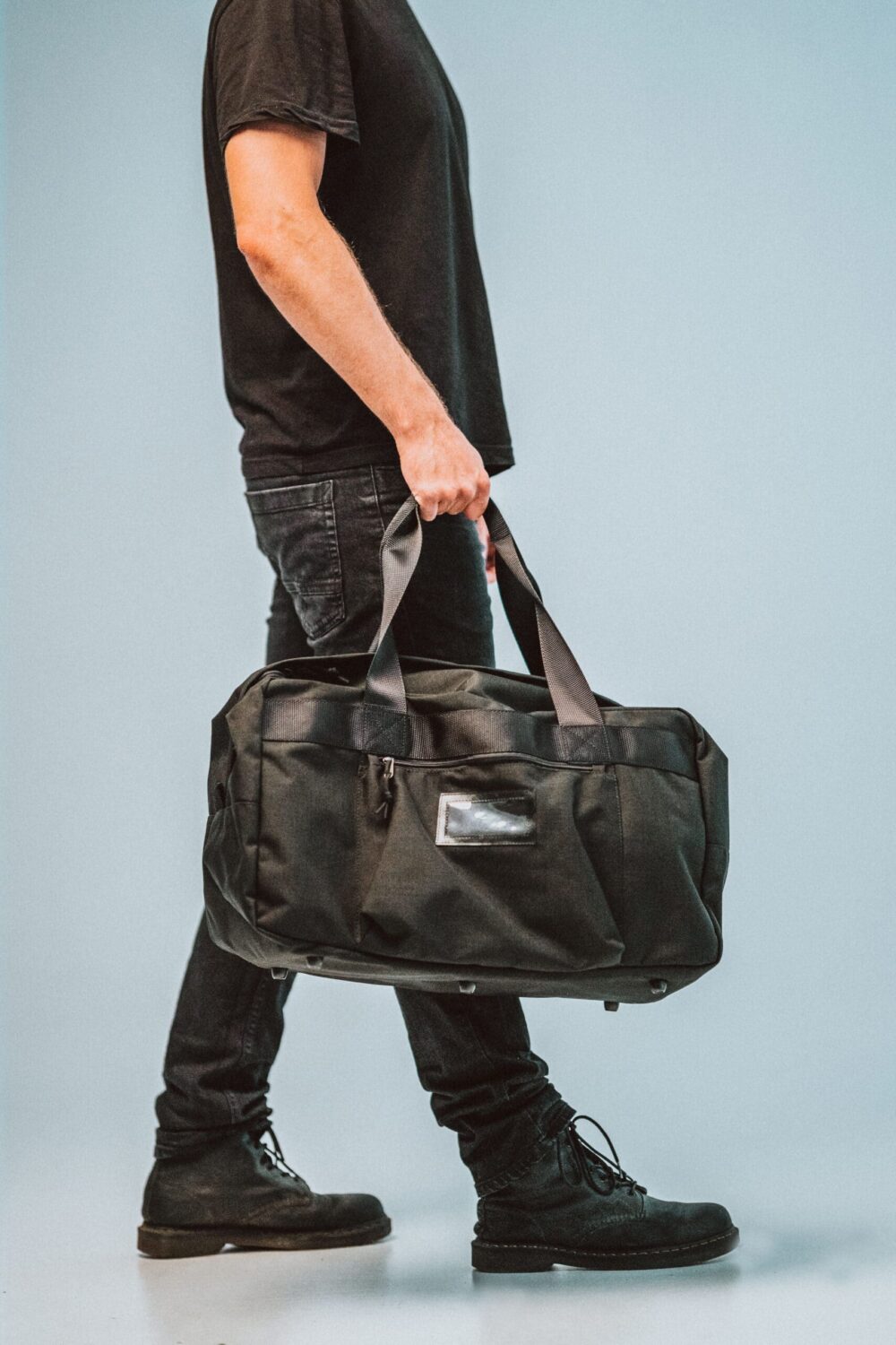 a man carrying a black duffel bag.