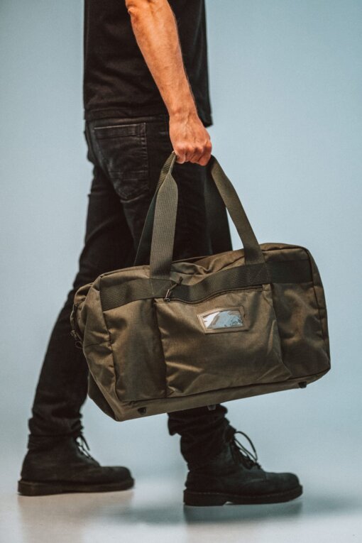 a man carrying a duffel bag on his feet.