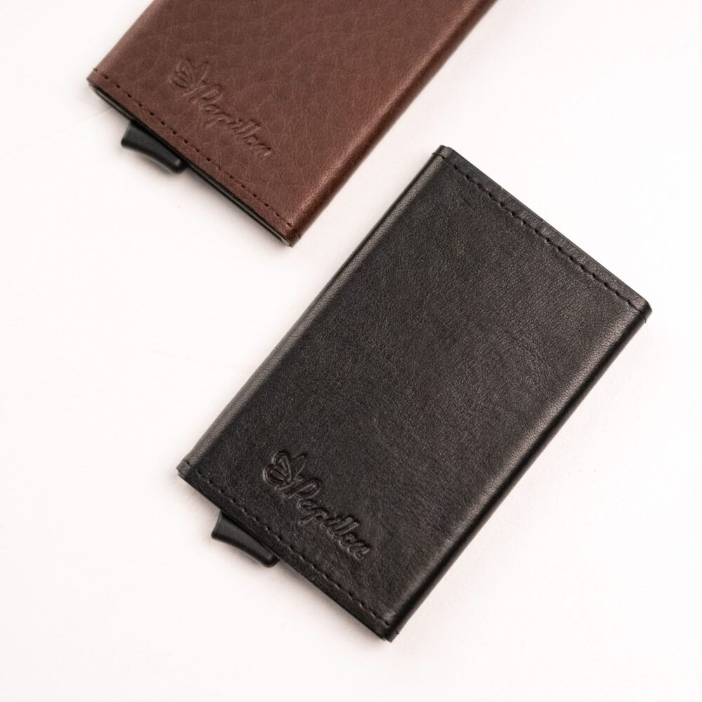 two wallets sitting next to each other on a white surface.