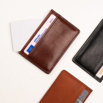 three different types of leather wallets on a white surface.