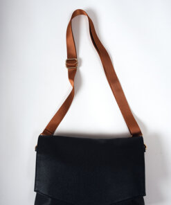a black purse with a brown strap on a white background.