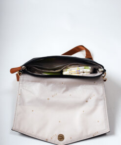 a white purse with a brown handle on a white surface.