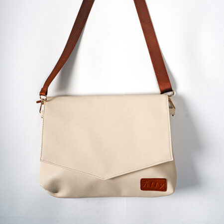 a white purse with a brown strap hanging on a wall.