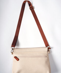 a white purse with a brown strap hanging from it.