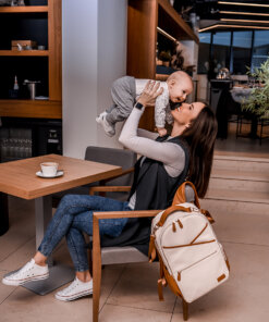 a woman sitting at a table with a baby in her lap.