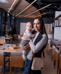 a woman holding a baby in a restaurant.