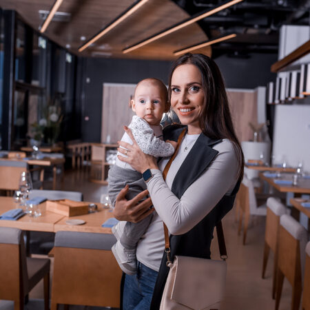 a woman holding a baby in a restaurant.