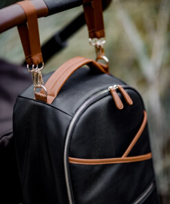 a black backpack with a brown leather handle.