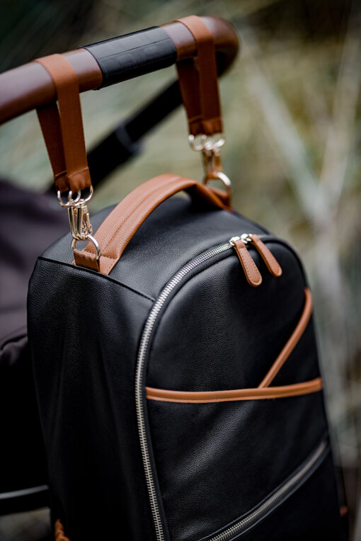 a black backpack with a brown leather handle.