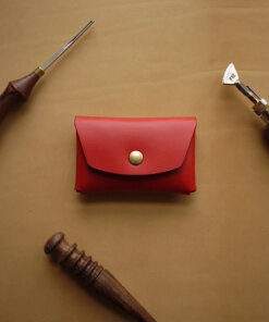 a red wallet sitting on top of a table next to a pair of scissors.