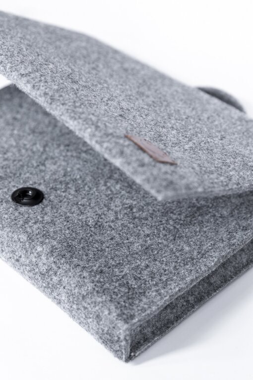 a close up of a gray felt bag on a white surface.