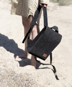 a person carrying a black bag on a beach.