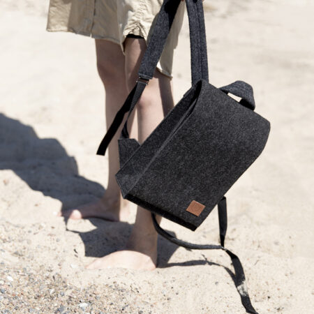 a person carrying a black bag on a beach.