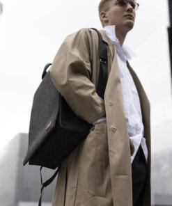 a man in a trench coat carrying a black bag.