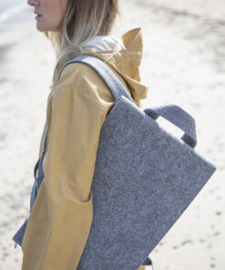 a woman carrying a gray bag on the beach.