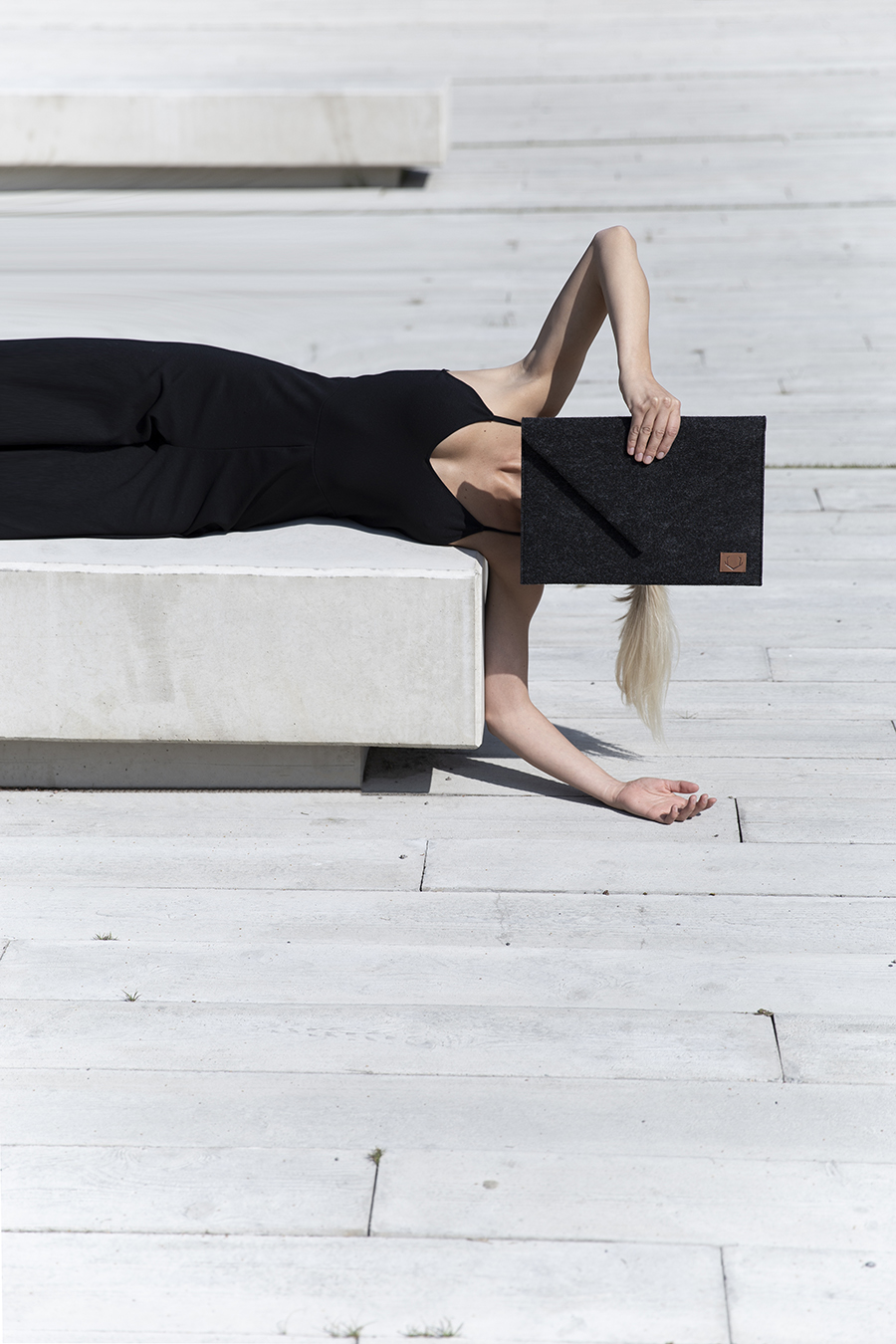a woman laying on top of a white bench.