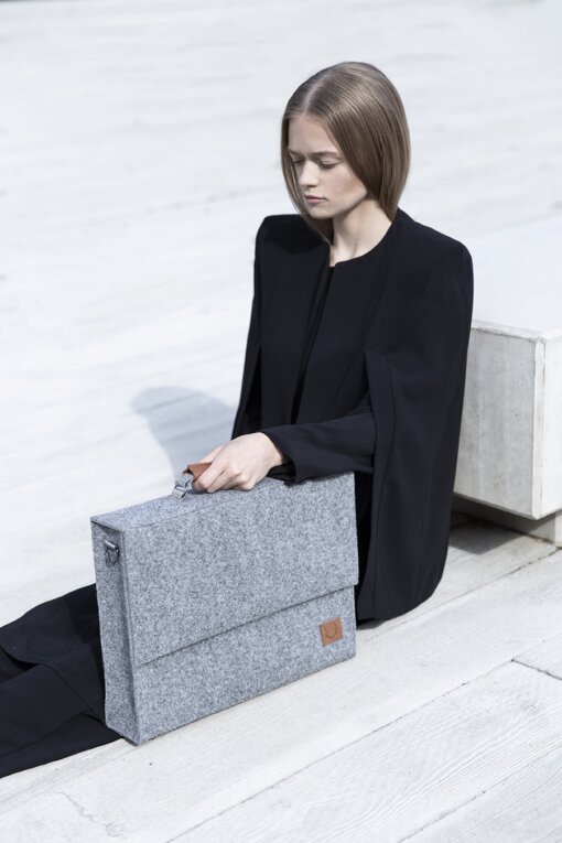 a woman sitting on the ground holding a briefcase.