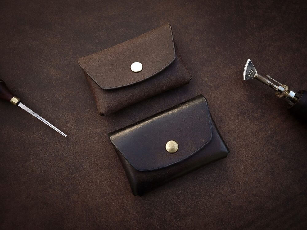 a knife and a wallet sitting on a table.