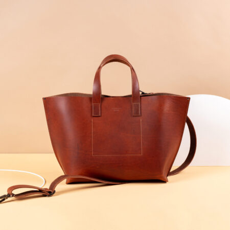 a brown leather bag sitting on top of a table.