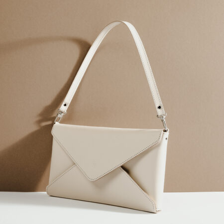 a white purse sitting on top of a white table.
