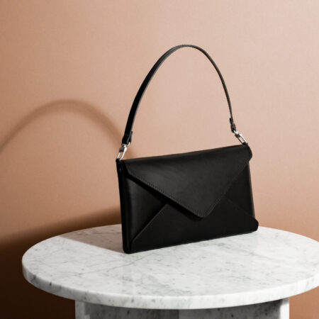 a black purse sitting on top of a white table.