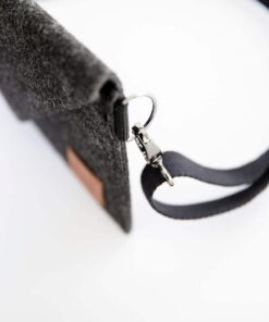 a black purse with a leather handle on a white surface.