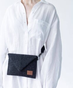 a woman is wearing a white shirt and a black bag.