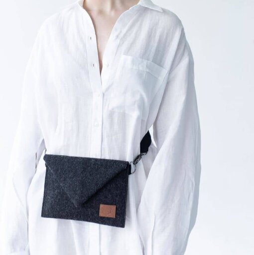 a woman is wearing a white shirt and a black bag.