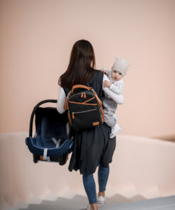 a woman carrying a baby in a backpack.