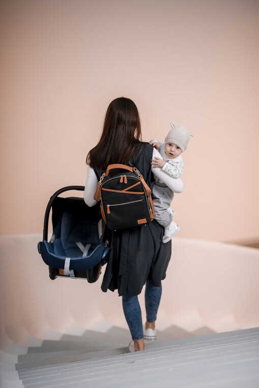 a woman carrying a baby in a backpack.