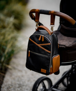 a black and brown backpack hanging from a stroller.