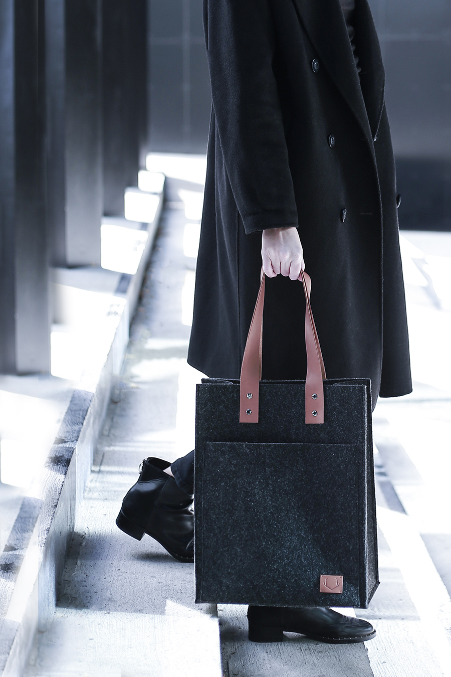 a man in a black coat carrying a black briefcase.