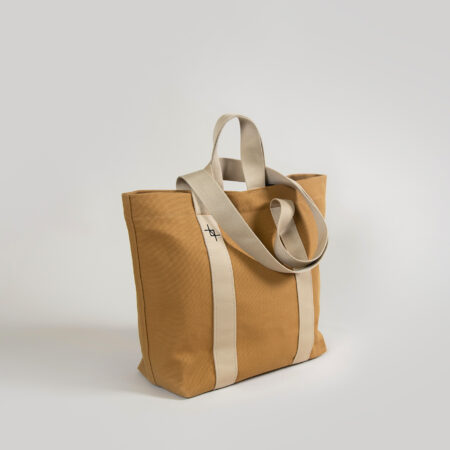 a tan and white tote bag on a white background.