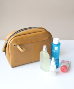 A DOUGLAS Toiletry Bag - Mustard with several items inside.