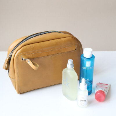 A DOUGLAS Toiletry Bag - Mustard with several items inside.