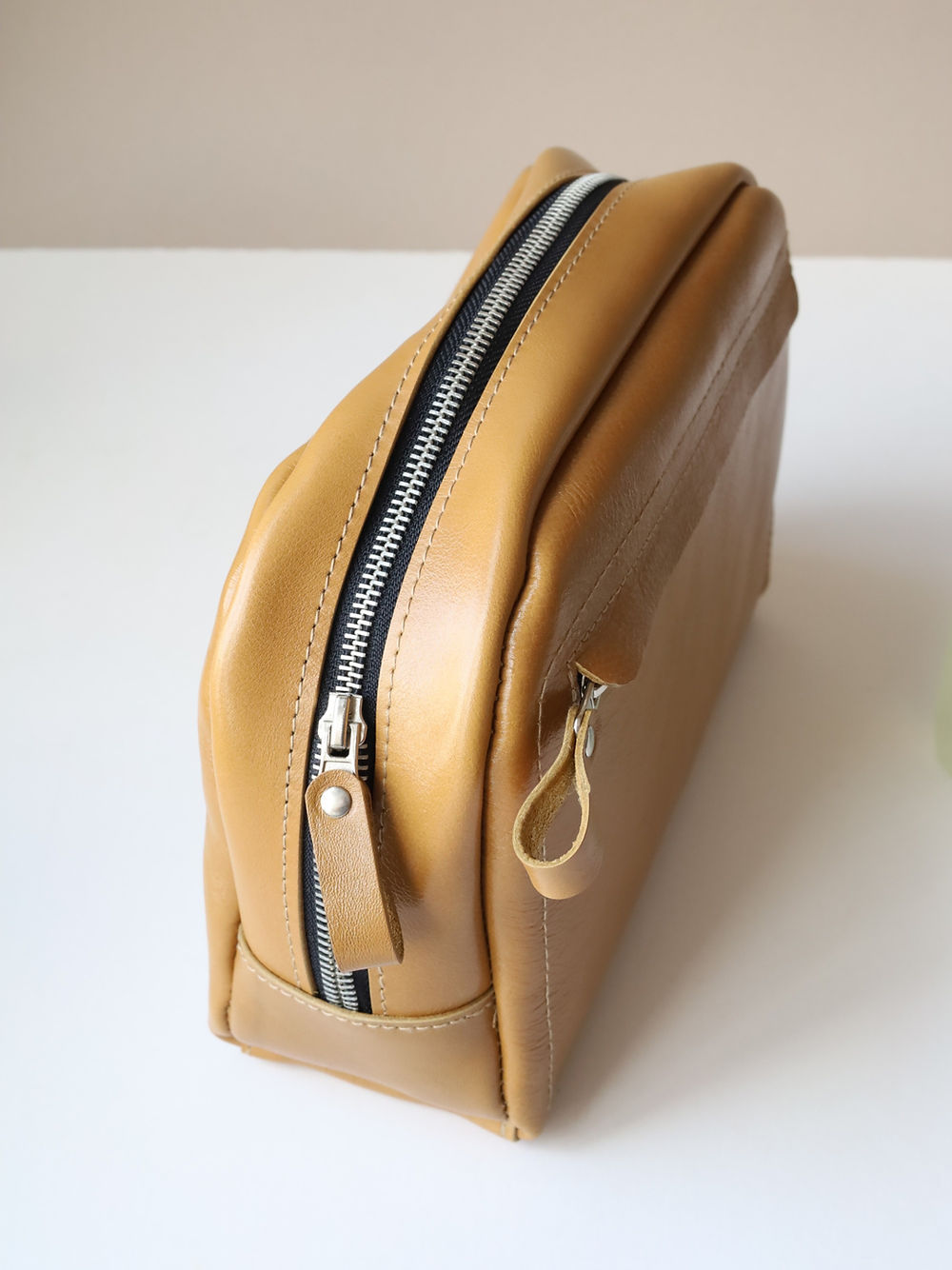 A DOUGLAS Toiletry Bag - Mustard sitting on a table.