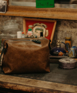 Un bolso de cuero marrón se encuentra encima de un mostrador.
