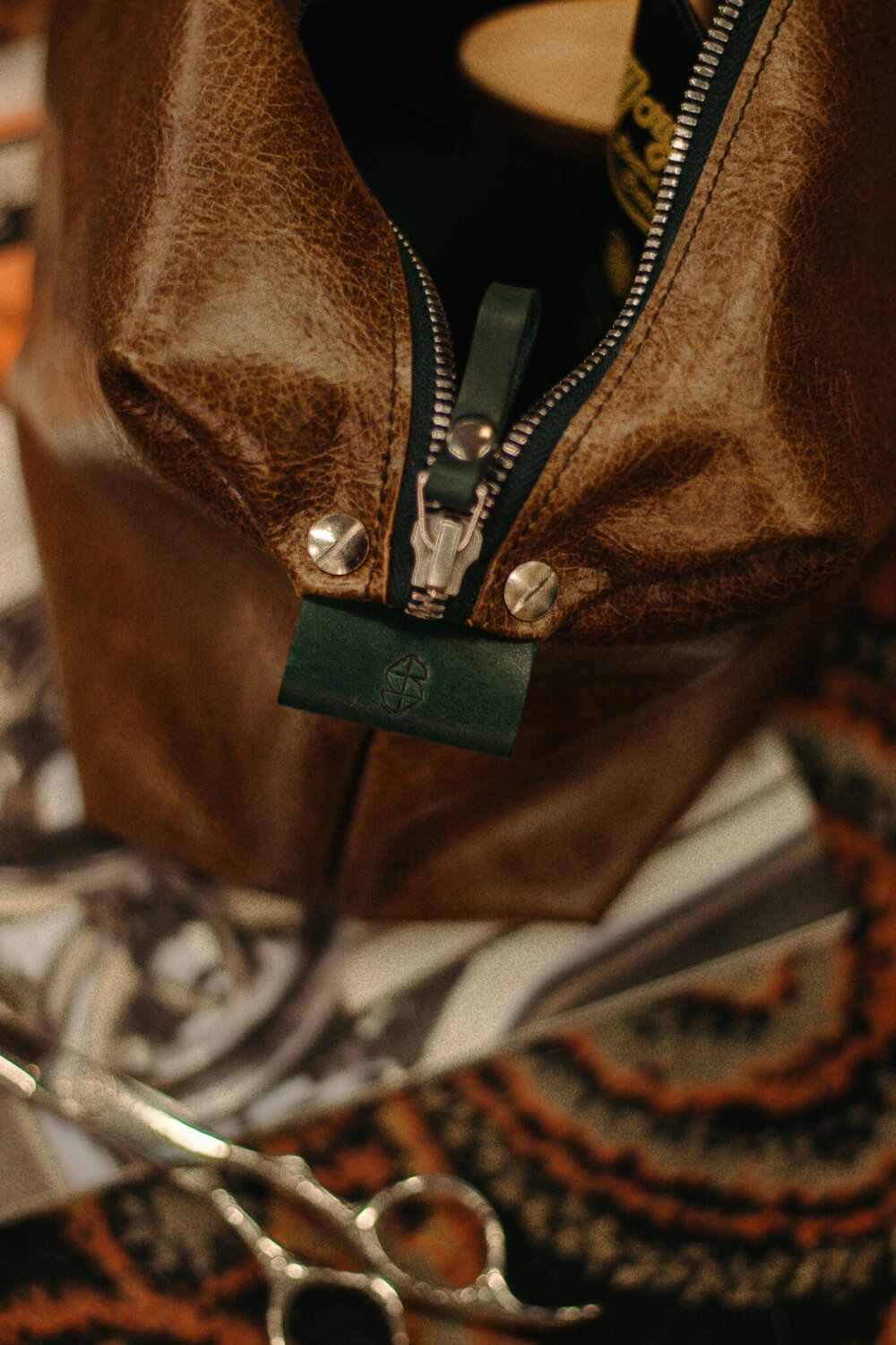Un bolso de cuero marrón con unas tijeras.
