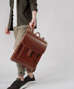 Un hombre que lleva una mochila de cuero marrón.